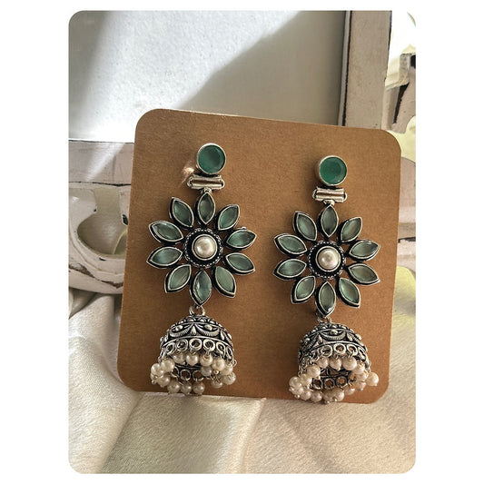 Weight per piece- 16 grams  Length- 5.5 cm  Stud Attachment  Base metal- Brass  Silver Toned Mint Stone Floral Studded Jhumkas